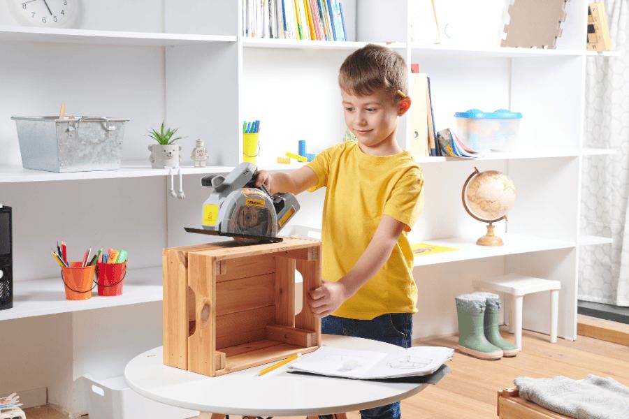 A child assembling a wooden kit at a table with an adult nearby
